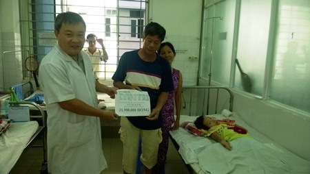 Gần 32 triệu đồng đến với cô gái bại não bị bỏng nặng - 1 Bác sĩ Phạm Trần Xuân Anh trao tiền của bạn đọc Dân trí tới ông Ngô Đức Diện