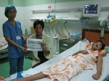 Đại diện Bệnh viện Phụ sản - Nhi Đà Nẵng trao tiền của bạn đọc Dân trí cho hai bố con anh Luân