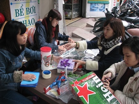 Các bạn gái tất bật gói quà để ông già Noel đưa đến tặng các bé