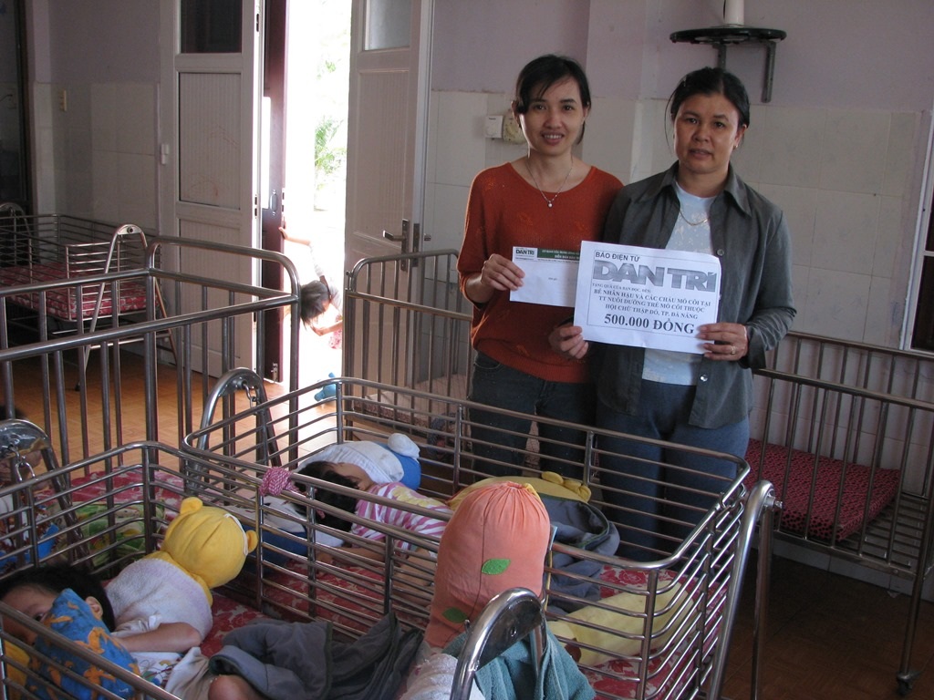 Đại diện Trung tâm nuôi dưỡng trẻ mồ côi Đà Nẵng nhận tiền của bạn đọc Dân trí ủng hộ