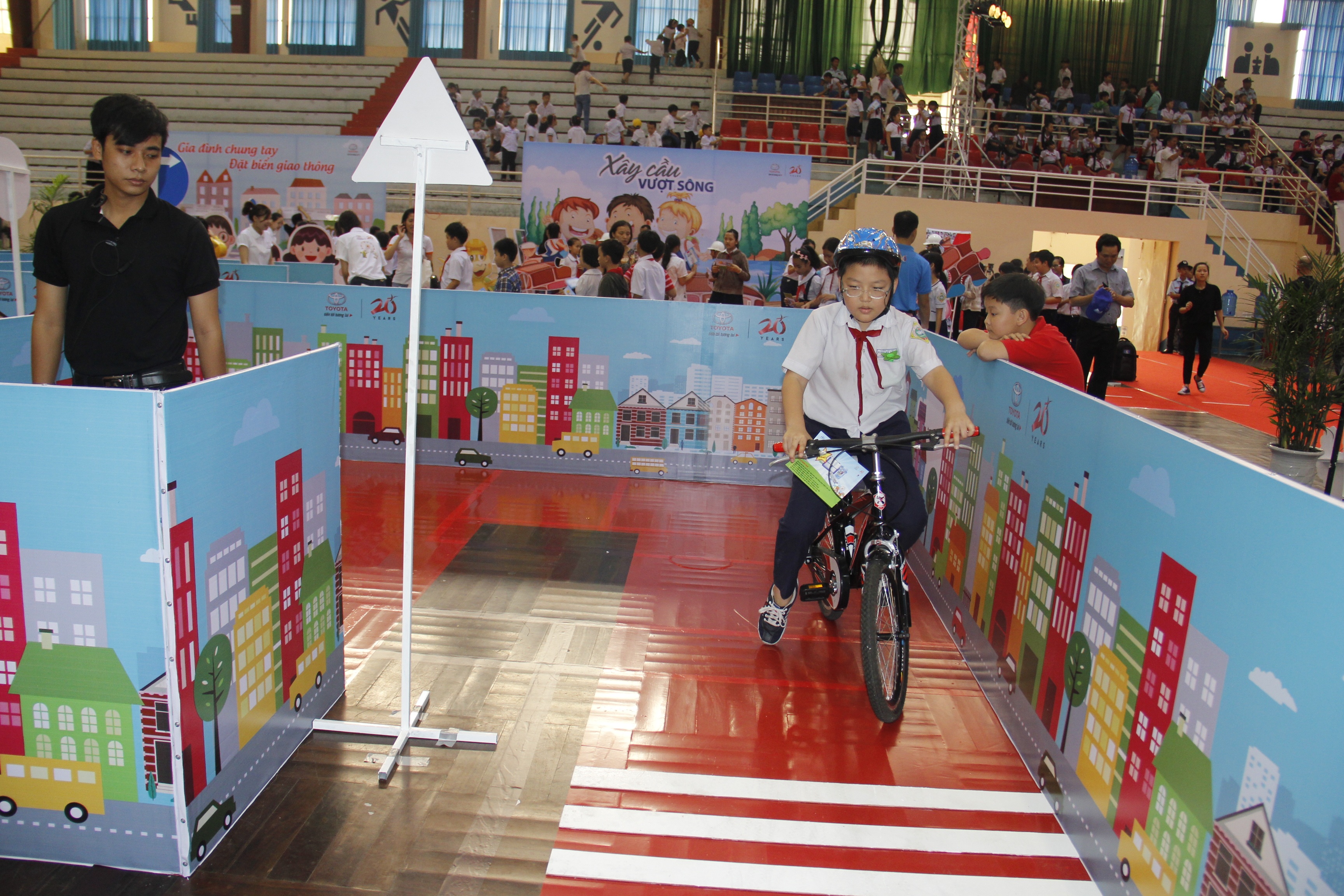 Các em học sinh được hướng dẫn đội mũ bảo hiểm an toàn khi tham gia giao thông