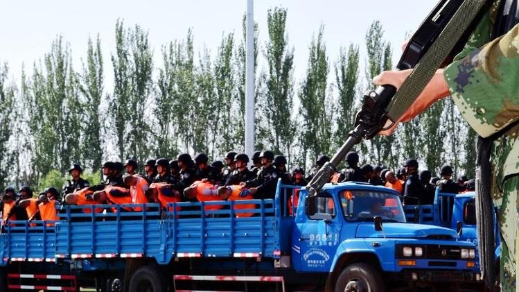 Trung Quốc tuyên án 81 phần tử khủng bố tại Tân Cương - 1 Các bị cáo được chuyển tới tòa án trên xe tải của cảnh sát.