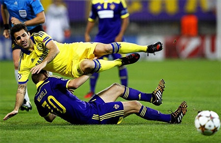 Fabregas ngã xuống sân sau pha vào bóng quyết liệt của đối thủ