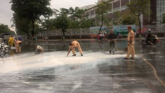 Cảnh sát giao thông giúp tài xế hốt 20 thùng sơn - 3 Sau khi giúp dân hốt sơn, các cảnh sát giao thông làm vệ sinh đường