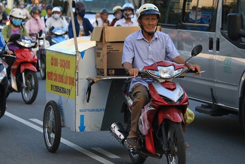 Hơn 3 tháng nay, nhiều người dân Đà Nẵng đã quen thuộc với hình ảnh ông Nguyễn Công Long (77 tuổi) đi xe máy kéo theo một cái thùng nổi bật với dòng chữ: “Cũ cho - sạch cho. Người cần dùng lấy dùng”. Đó là ông đang đi gom quần áo cũ cho những người nghèo. (Ảnh: Khánh Hồng)