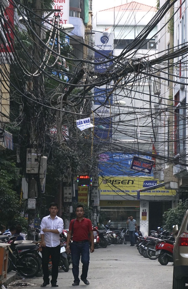Người Hà Nội vẫn coi thường “tử thần” và người phụ nữ dập lửa trên phố - 2 Mạng cáp viễn thông và đường dây điện tại Hà Nội vẫn là một nỗi ám ảnh với người dân Thủ đô. Những bó dây chằng chịt được buộc tạm bợ, chạy vắt vẻo, nhiều chỗ như muốn sà xuống người đi đường vẫn là một hình ảnh đặc sản của Thủ đô. (Ảnh: Hữu Nghị)