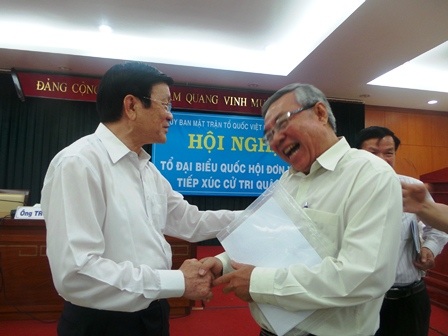 Chủ tịch nước Trương Tấn Sang (phải) trò chuyện cùng bà con cử tri sau buổi tiếp xúc