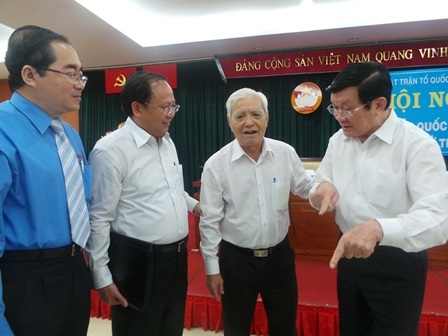 Chủ tịch nước Trương Tấn Sang (phải) trò chuyện cùng bà con cử tri sau buổi tiếp xúc