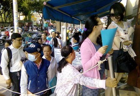 Lo tăng lệ phí, hàng trăm người “rồng rắn” đợi làm hộ chiếu - 1 Đã xế chiều nhưng người dân vẫn đến và kiên nhẫn sắp hàng làm thủ tục cấp hộ chiếu