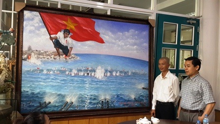 Đấu giá bức tranh “Gạc Ma - vòng tròn bất tử” tri ân 64 liệt sĩ Gạc Ma - 1 Họa sĩ Bùi
Lệ Trang (áo trắng) giới thiệu về bức tranh “Gạc Ma – Vòng tròn bất tử”
