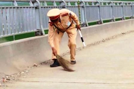 Chiến sỹ CSGT, Công an Thanh Hóa quét dọn đá đổ trên đường khi có đoàn đua xe đạp sắp đi qua.