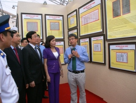 Lãnh đạo Bộ TT&TT tỉnh Ninh Bình và người dân nghe thuyết minh về các tư liệu trong triển lãm.