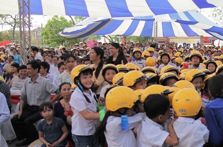 Các em học sinh vui mừng nhận mũ bảo hiểm.