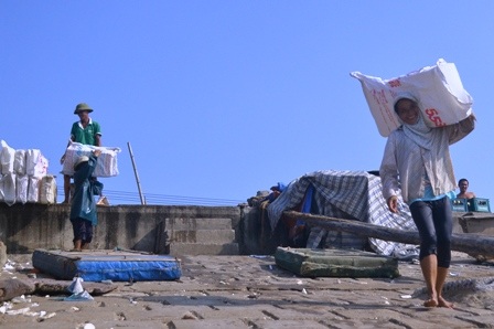 Những người phụ nữ làm nghề bốc vác đá lạnh lên tàu.