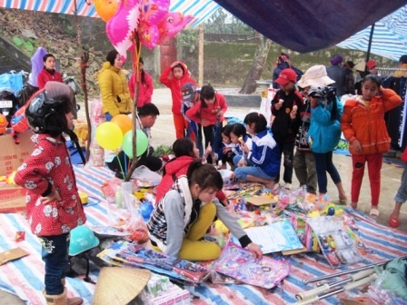 Trẻ em được bố mẹ đưa đến chơi chợ ngày Tết.