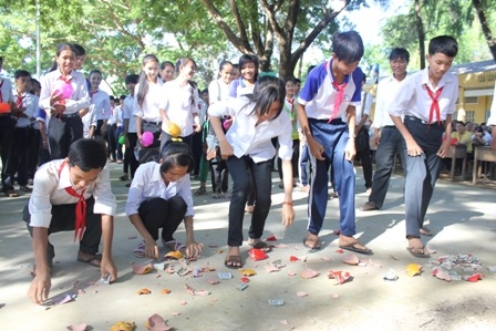 Các em học sinh mổ heo đất giúp bạn nghèo đến lớp.