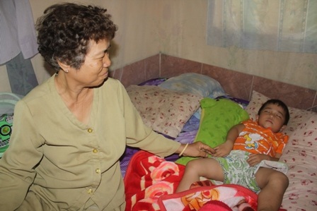 Bà Mậu đang chăm sóc đứa cháu nội mới 3 tuổi luôn khóc đòi cha