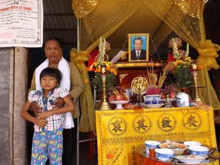 Bà Quang và đứa cháu ngoại bên ban thờ người thân