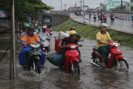 Xe gắn máy cố gắng vượt qua tuyến đường bị ngập