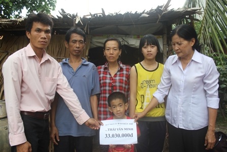 Đại diện lãnh đạo chính quyền địa phương trao tiền bạn đọc báo Dân trí ủng hộ cho gia đình ông Minh