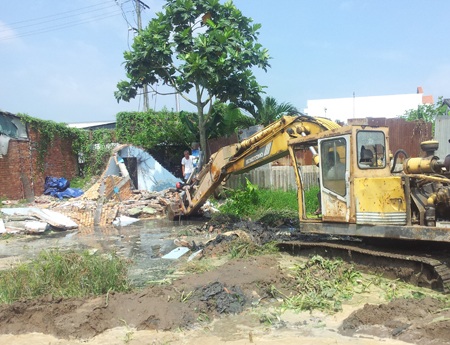 Lực lượng chức năng đang cho máy ủy san lấp mặt bằng ở khu vực nhà bà Hai và ông Hiếu