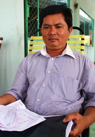 Ông Minh cùng hồ sơ bệnh án sau khi bị bà Liễu đánh