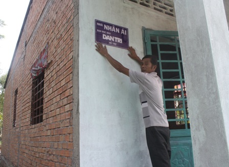 Anh Thành- Chồng chị Phượng treo bảng hiệu lên căn nhà mới do bạn đọc báo Dân trí hỗ trợ