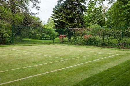 Sân tennis của dinh thự với mặt cỏ xanh mượt.