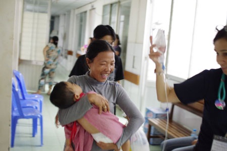 Niềm vui của mẹ Tuấn Anh khi nhận em từ tay các bác sĩ, y tá và tình nguyện viên