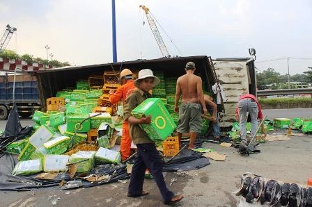 Xe tải chở nước ngọt lật giữa đường, người giúp, kẻ "hôi của" - 3 Trong khi có rất nhiều người dân xung quanh phụ giúp tài xế...