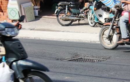 Hàng loạt hố sâu xuất hiện giữa đường sau khi được trải nhựa.
