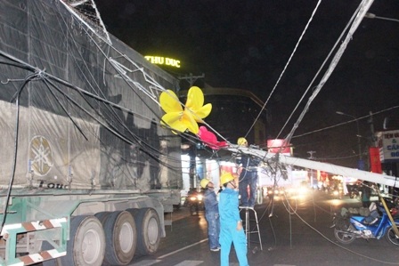 Chiếc xe đầu kéo chở thùng hàng quá cao đã kéo đổ cột điện và giàn đèn trang trí.