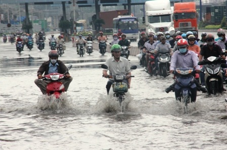 Hàng loạt phương tiện bì bõm lội qua khu vực ngập nước, nhiều xe bị chết máy phải dắt bộ lên cầu.
