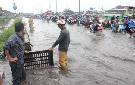 Nhân viên công ty thoát nước đô thị khơi dòng, mở nắp cống...để giải toả tình trạng ngập.