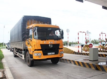 Nhân viên trạm thu phí Long Phước đang hướng dẫn xe tải vào làn để cân tải trọng xe.