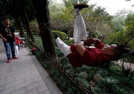 Thán phục người đàn ông có khả năng nằm ngủ vắt vẻo trên dây thừng - 1 Ông Liang có thể nằm thăng bằng và tập luyện ngay trên sợi dây thừng