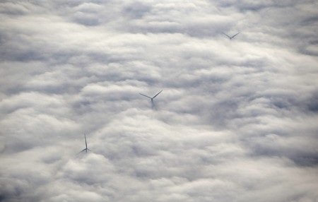 Những chiếc tua-bin gió bị bao phủ bên trong sương mù giày đặc ở ngoại ô thủ đô Amsterdam, Hà Lan.