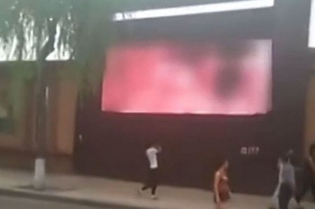Những người qua đường bị thu hút sự chú ý bởi nội dung khiêu dâm xuất hiện trên màn hình quảng cáo