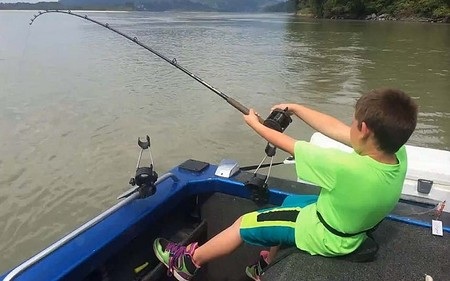 Cậu bé Kegan đang gồng mình để kéo cần sau khi con cá “khủng” cắn câu