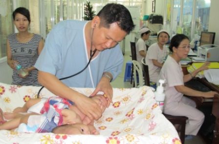 BS Trương Quang Định thăm khám cho bệnh nhi trước cuộc mổ