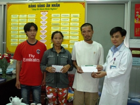 Ông Minh Hiển (bên phải) chuyển sự giúp đỡ của cộng đồng cho thân nhân người bệnh