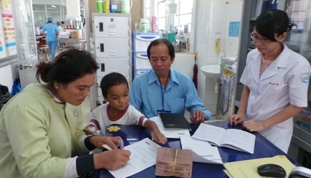 Đại diện bệnh viện Bệnh Nhiệt Đới làm thủ tục trao tiền cho gia đình bé Phát