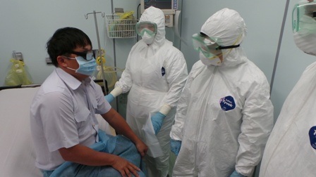 Bộ trưởng Kim Tiến (đứng giữa) thăm hỏi bệnh nhân giả định mắc Ebola