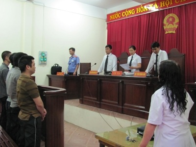 Một bị cáo vụ công an trấn tiền gái mại dâm được tuyên vô tội - 1 Các bị cáo (bìa trái) đứng nghe tòa tuyên án.