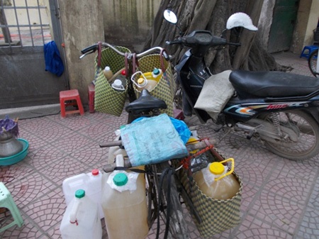 Hà Nội: 2.000 lít rượu “trữ” trong…21 săm xe ô tô - 4 Rượu săm được san sang các bình, can để tiêu thụ