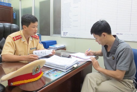 PV Báo CAND trao đổi với đại diện Phòng CSGT Công an Hà Nội.
