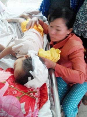 Chồng giận vợ… xử con rồi tự tử - 2 Bà M. đang chăm sóc con trai với vết thương nặng trên đầu.