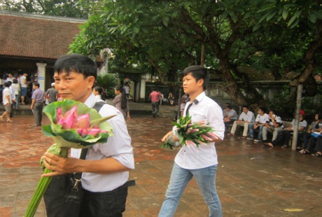 Nhiều sĩ tử và người nhà mang hoa và hương tới Văn Miếu cầu may.