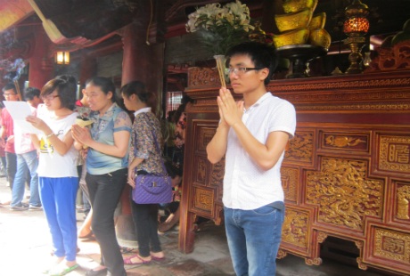 Sĩ tử và người nhà thắp hương cầu may mắn.