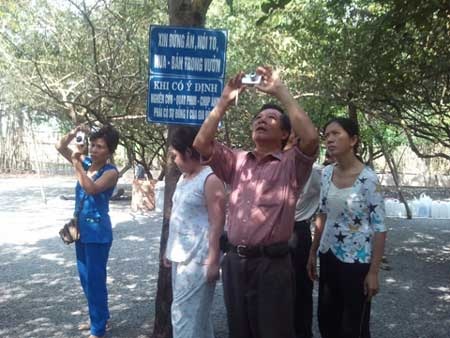 Lật tẩy chiêu bài “hiến vườn thiêng cho Nhà nước” - 1 Nguyễn Thị Kim Hồng (quần áo bó màu xanh) đang chụp hình trong vườn.